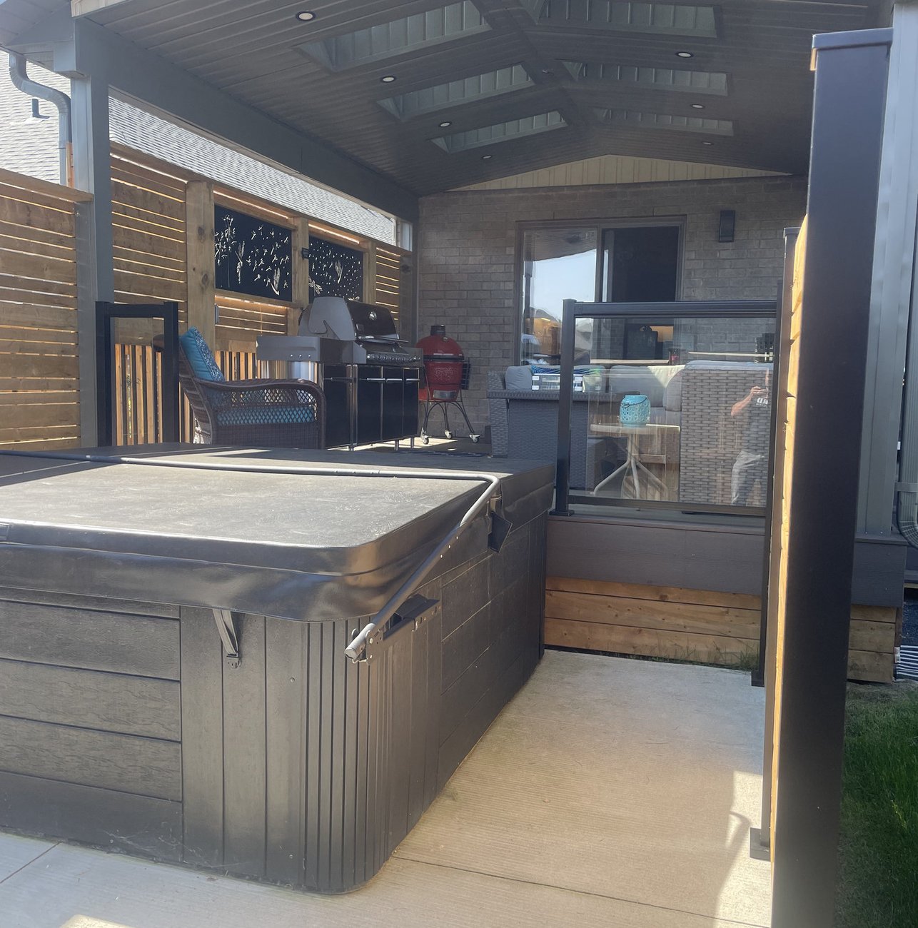 composite deck under a covered porch with hot tub built by Baird Construction in Woodstock ON